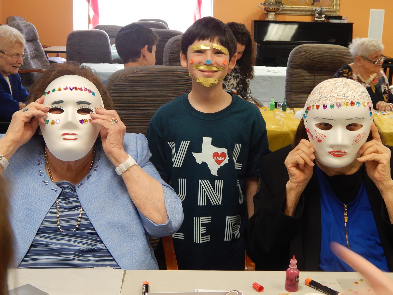 The Medallion residents are assisted by student in making masks for Purim